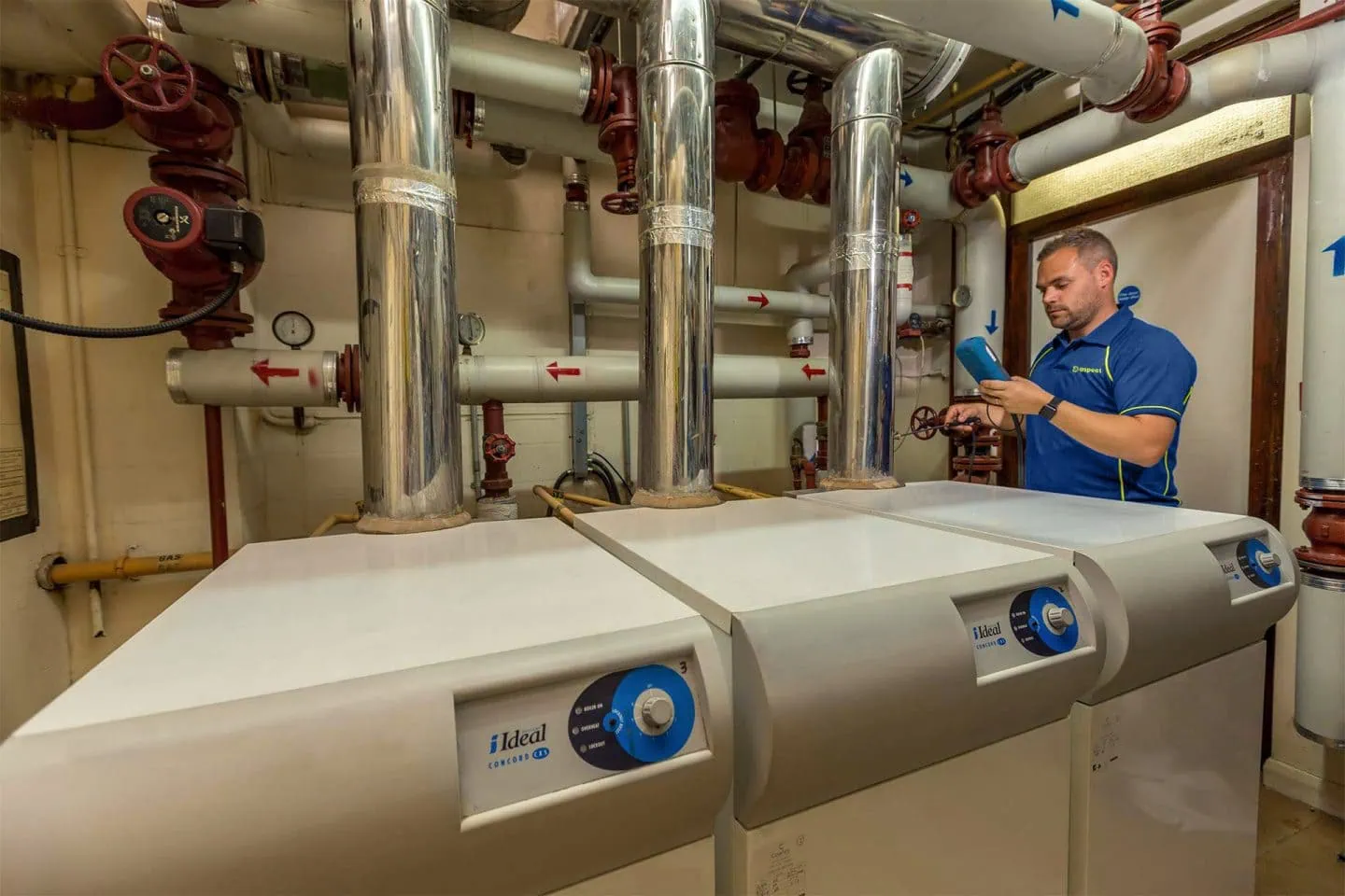 An Aspect commercial gas engineer checking boiler operation in a plant room.