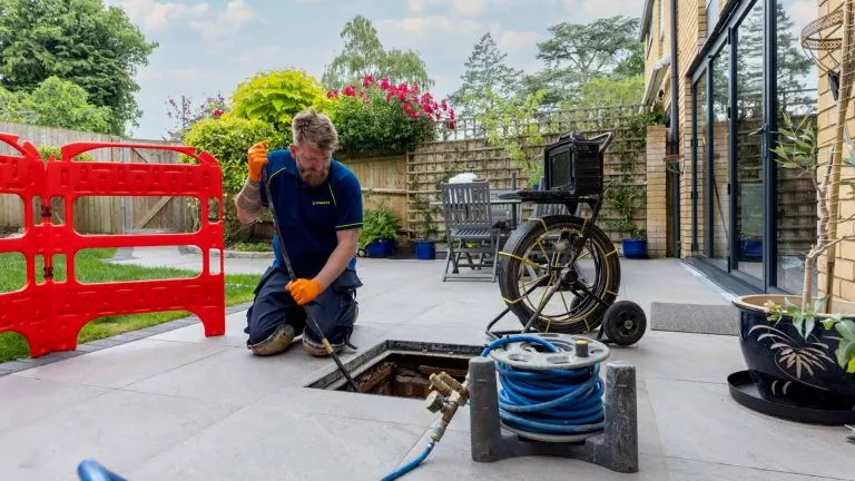 An Aspect drainage engineer installs a patch repair to an underground soil water pipe that was cracked.