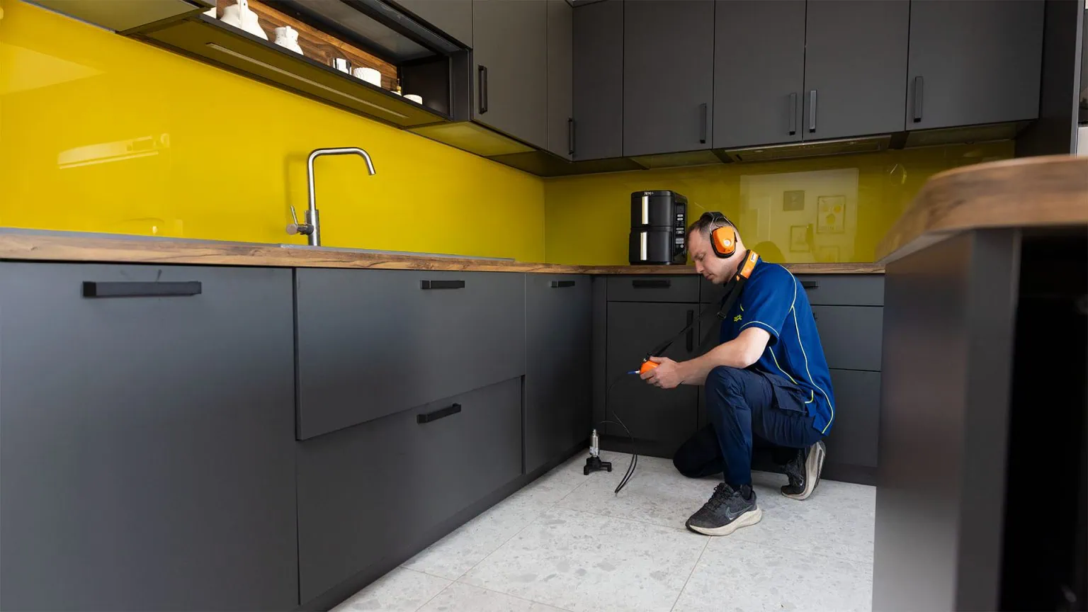 An Aspect trace and access plumber detection a leak in a kitchen using acoustic test equipment.